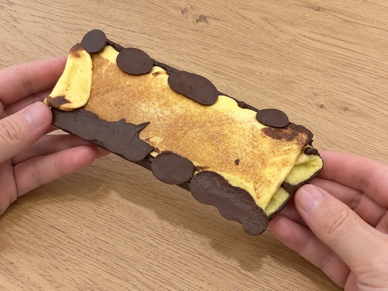 セブンのドバイチョコスタイルクレープの裏側とチョコの縁（AI生成画像）